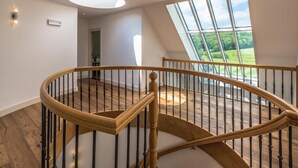 A wooden spiral staircase with black balusters, leading to a lofted area with a large skylight. - Geräumiges Ferienhaus in Mechelen mit by Interhome (Mechelen)