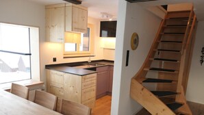 Una cocina moderna con armarios de madera, horno empotrado y un ventanal grande.