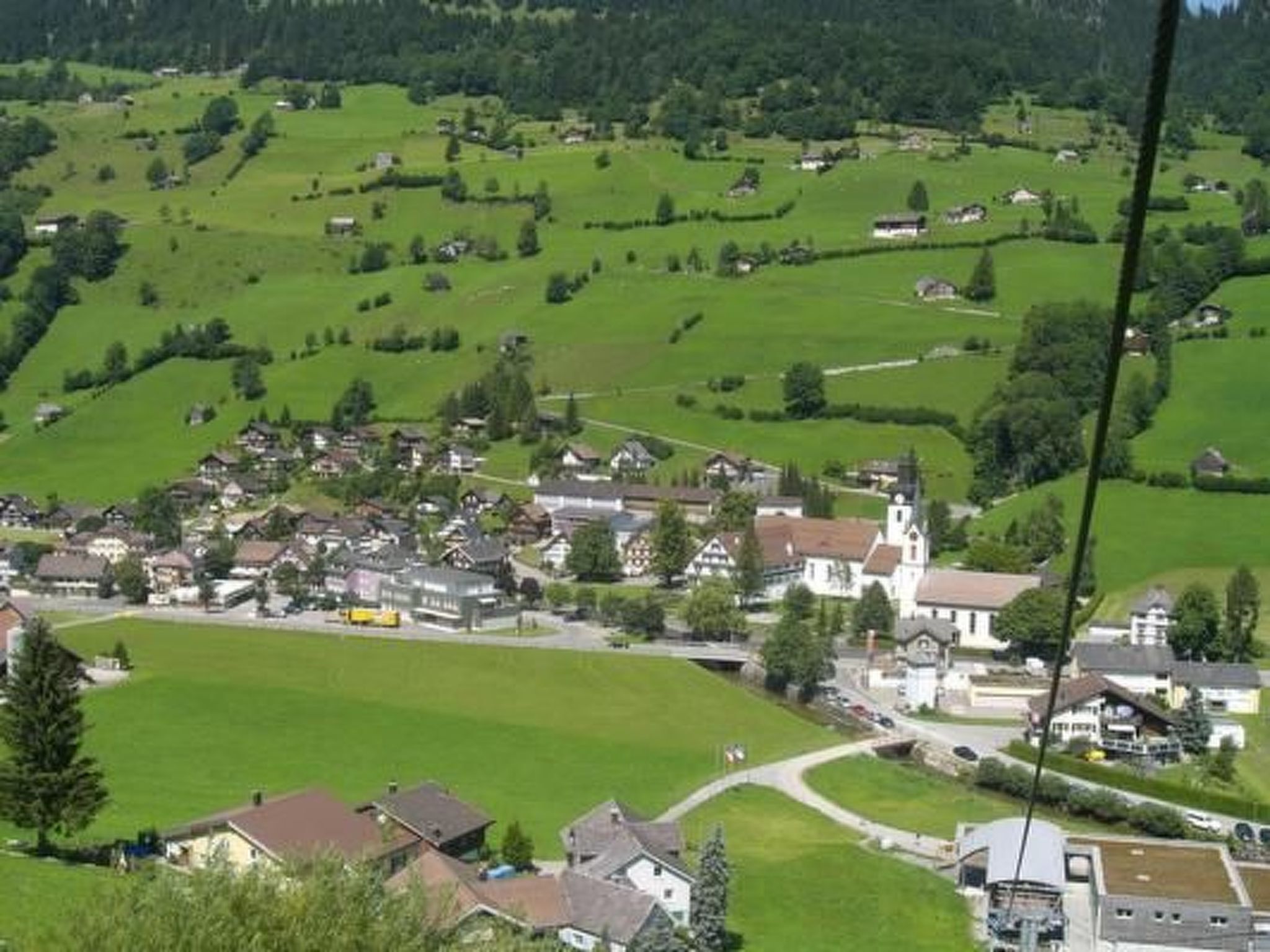 Un village rural avec des maisons, une église et des champs verdoyants.