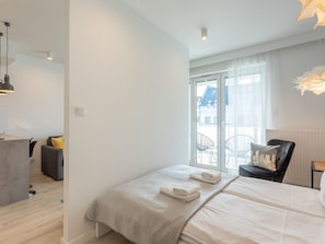 Ein modernes Hotelzimmer mit einem großen Bett, einem Schreibtisch und einem Sessel.