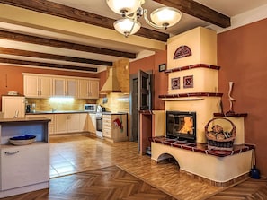 Una cocina con chimenea, vigas de madera y suelo de espiga.