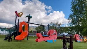 A playground with a slide, swings, and a climbing structure. - Wohnung mit Kamin N2 by Interhome (Zuberec)