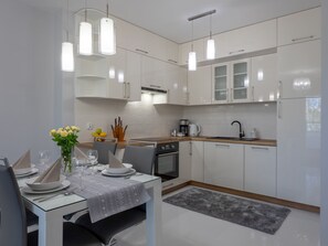 A modern kitchen with white cabinets, a wooden countertop, and pendant lighting. - Helle, stylische Ferienwohnung Dune 737 by Interhome (Swinoujscie)