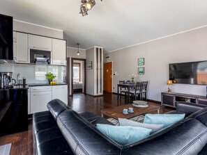 Ein modernes Wohnzimmer mit Küche, Essbereich und einer Sitzecke inklusive Sofa und Couchtisch.