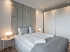 A modern hotel room with a large bed, two bedside tables with lamps, a grey headboard, and a wardrobe. - Urlaub auf Usedom, Apartment Sun Towers A53 by Interhome (Swinoujscie)