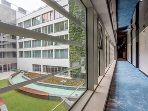 A modern building with a courtyard, large windows, and a blue-tiled corridor. - Stilvolle Ferienwohnung am Meer by Interhome (Swinoujscie)