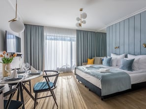 A modern hotel room with a large bed, a desk with a chair, a TV, and a large window with curtains. - Stilvolle Ferienwohnung am Meer by Interhome (Swinoujscie)
