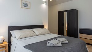 Una camera da letto ordinata con un letto, un comodino e un armadio.