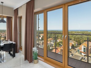 Ein modernes Zimmer mit Essbereich, großen Schiebeglastüren und Blick auf eine Wohngegend.