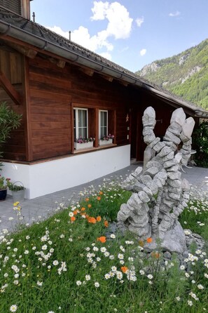A wooden building with a stone sculpture in front. - Steinideen by Interhome (Meiringen)