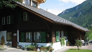 Een klassiek chalet met een schuin dak, houten gevel en groene luiken.