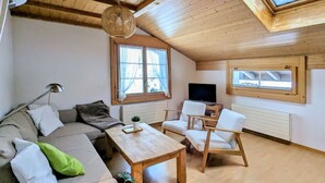 A cozy living room with a sofa, two armchairs, a coffee table, and a TV. - Margrit West by Interhome (Lauterbrunnen)