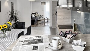 Moderni keittiö, jossa on ruokailutila. Siellä on esillä sanomalehti, kahvikuppi ja kulho täynnä lehtiä.