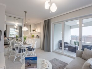 En modern lägenhet med matplats, kök och balkong.