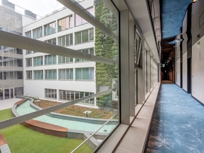 A modern building with a courtyard, large windows, and a blue-tiled corridor. - Elegante Ferienwohnung auf der Insel Usedom by Interhome (Swinoujscie)