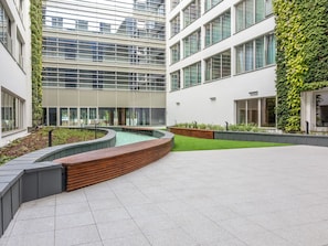 A modern building with a courtyard featuring a water feature, seating areas, and green walls. - Elegante Ferienwohnung auf der Insel Usedom by Interhome (Swinoujscie)