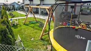 A residential area with a trampoline, swing set, and a fenced yard. - Haus 1 in Sarbinowo by Interhome (Sarbinowo)