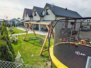 A residential area with a trampoline, swing set, and a fenced yard. - Haus 1 in Sarbinowo by Interhome (Sarbinowo)