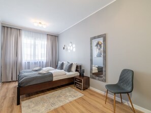 A modern bedroom with a bed, a chair, a dresser, and a mirror. - Apartment Maja by Interhome (Swinoujscie)