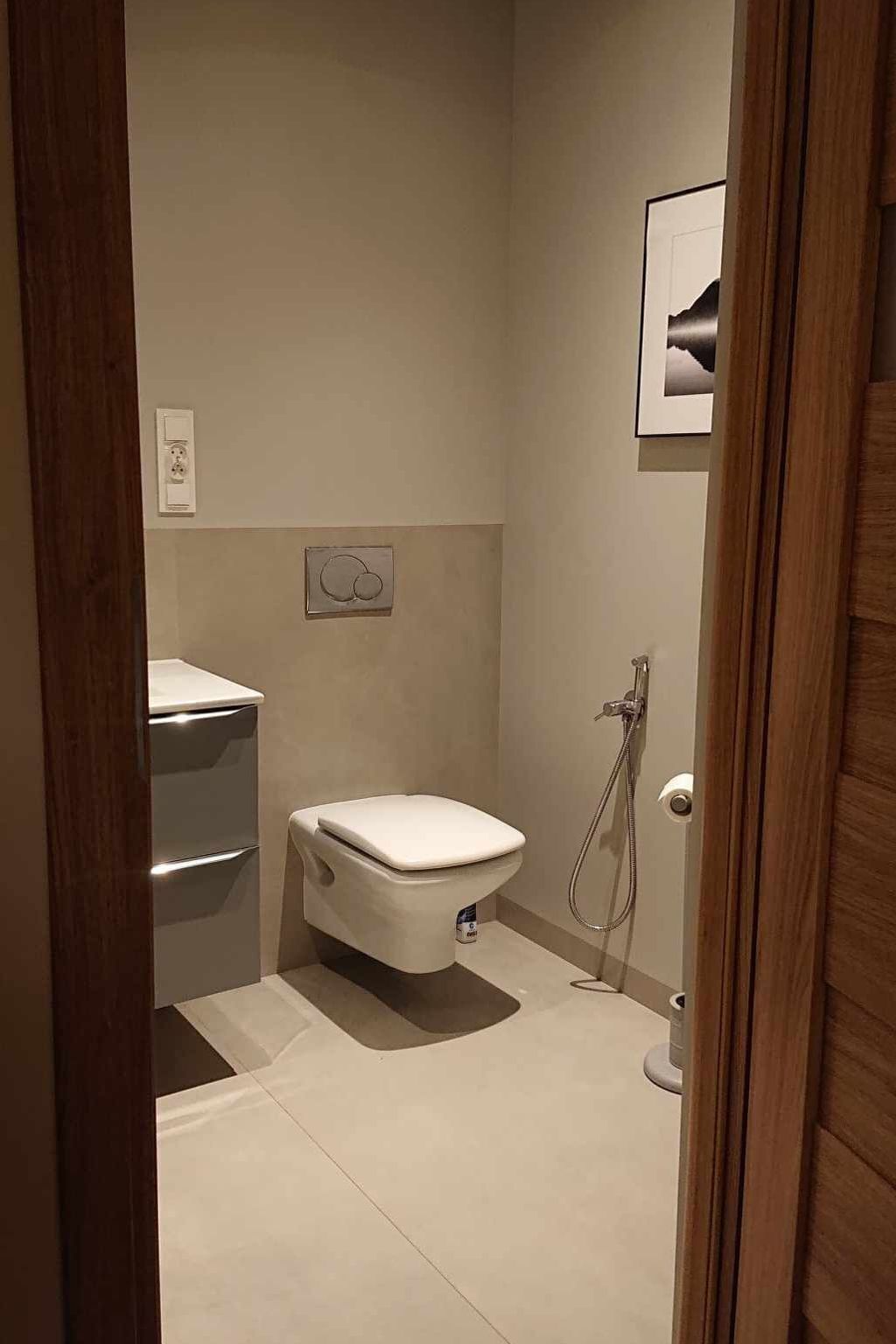 Une petite salle de bain moderne, équipée de toilettes, d’une douche et d’un lavabo.