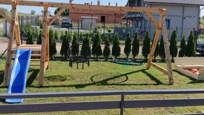 Um parquinho com balanço, escorrega e um espaço circular para sentar.