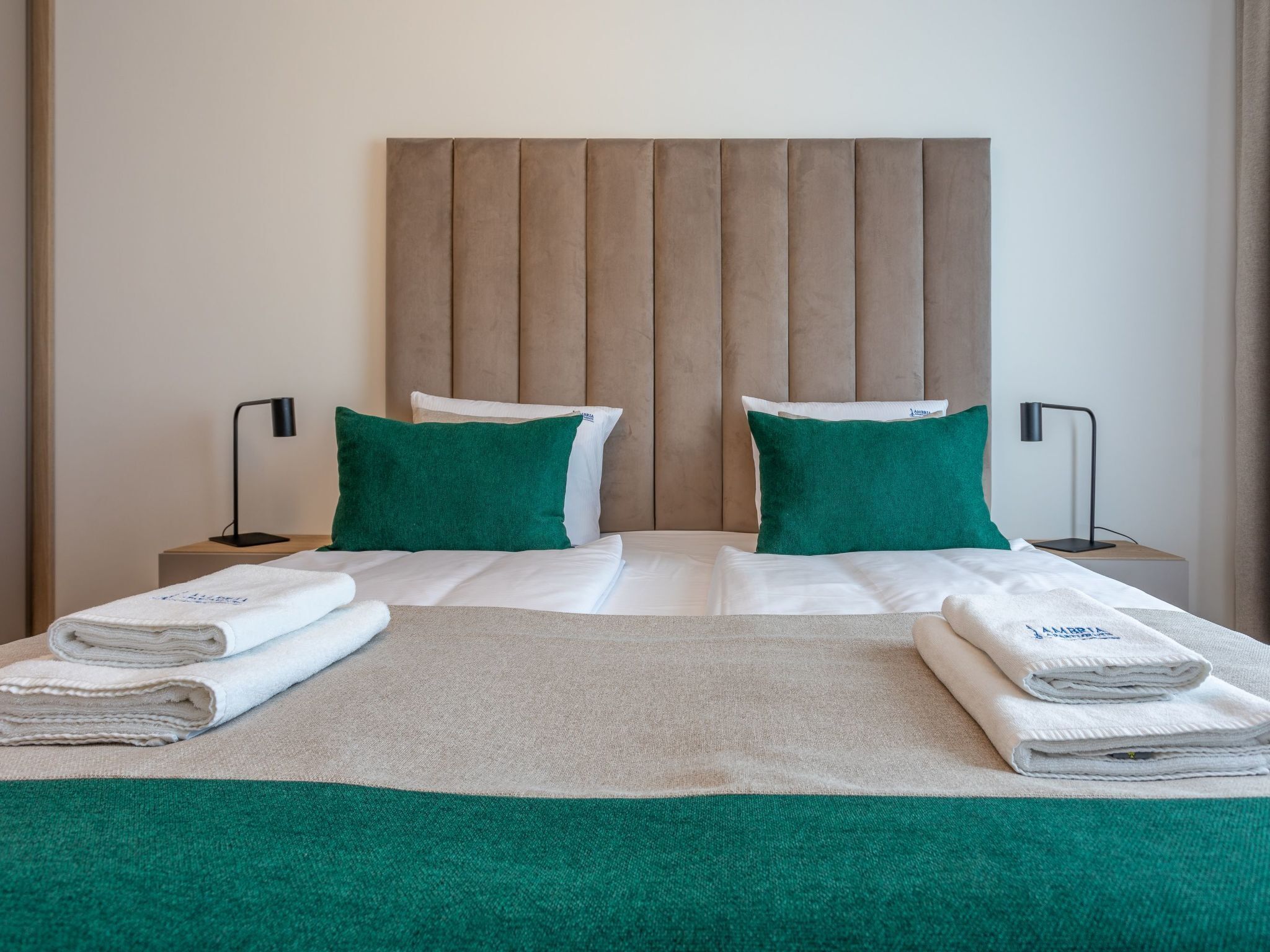 Ein Hotelzimmer mit einem Bett, zwei Nachttischen und einem Kopfteil.