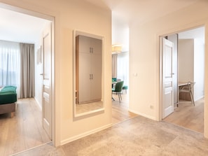 A hotel room with a bed, a wardrobe, a dining area with chairs, and a hallway. - mit Balkon an der Ostsee by Interhome (Swinoujscie)