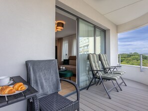 A balcony with wicker chairs, a table with croissants, and a view of a cityscape. - mit Balkon an der Ostsee by Interhome (Swinoujscie)