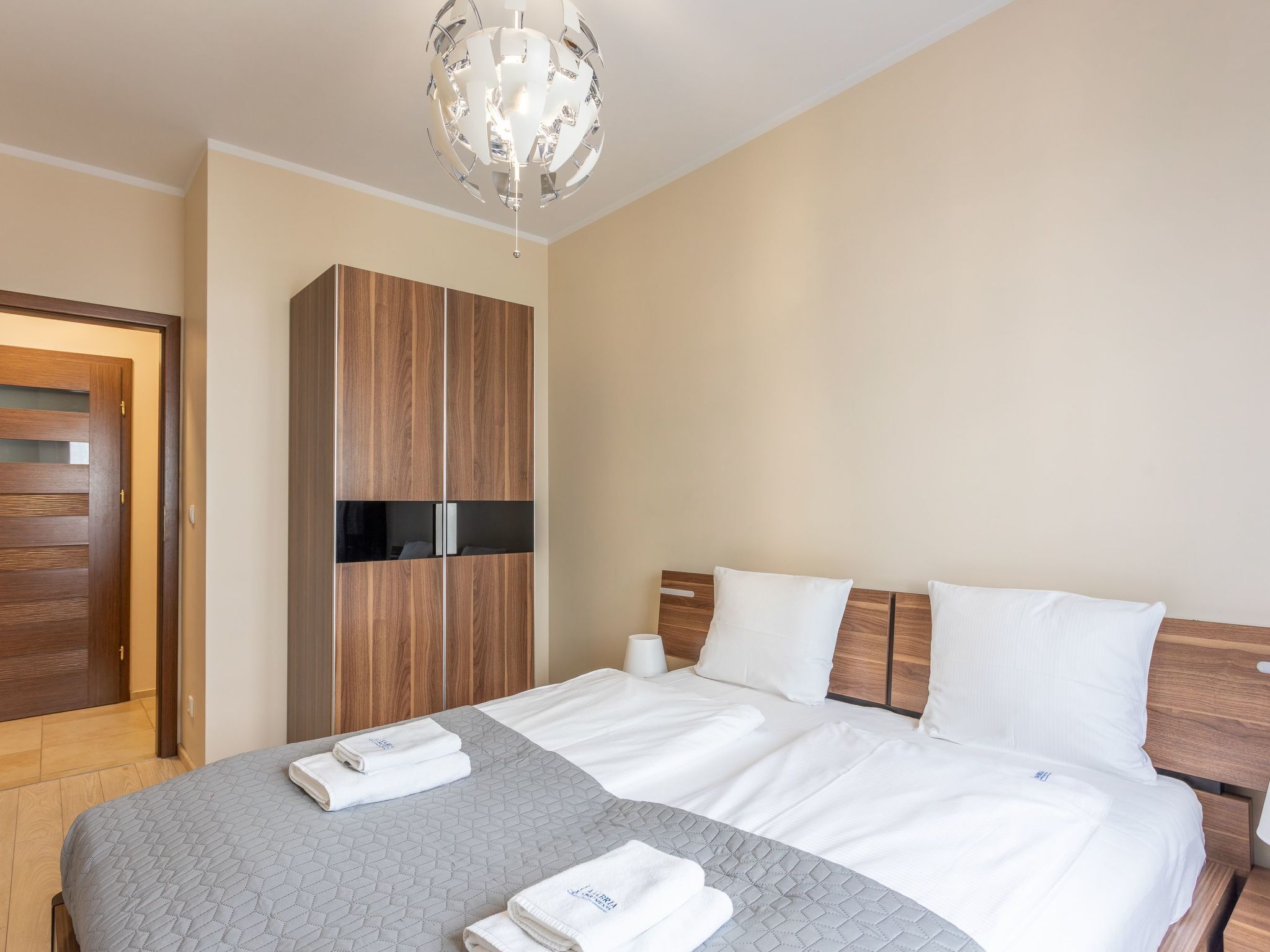 Ein Hotelzimmer mit Bett, Schrank, einer Kandelaber und einer Tür.