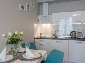 A modern kitchen with white cabinets, a sink, and a coffee maker. - Pegaz 17 an der Strandpromenade by Interhome (Swinoujscie)