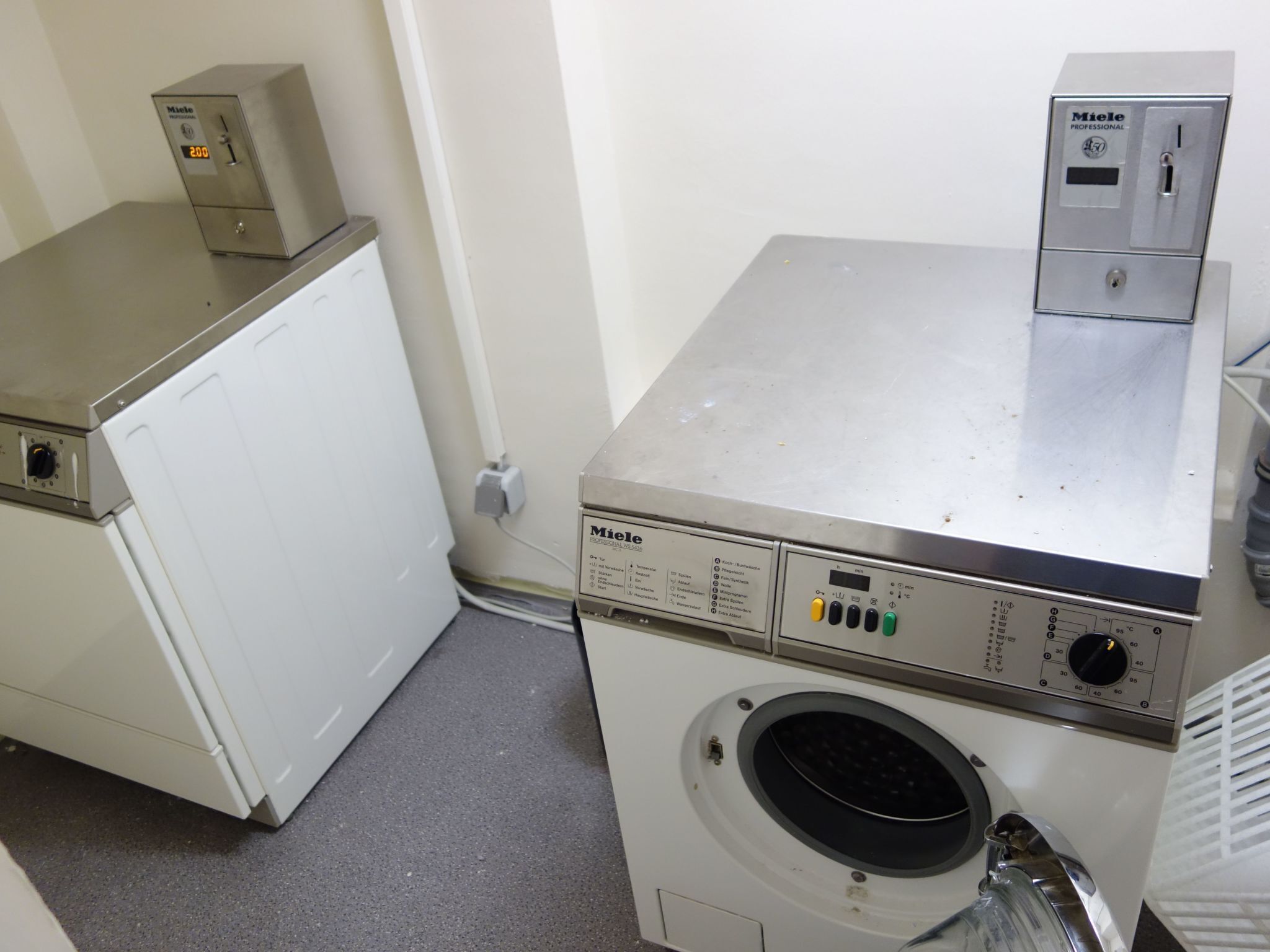 A laundry room with a front-loading washing machine and a stacked dryer.