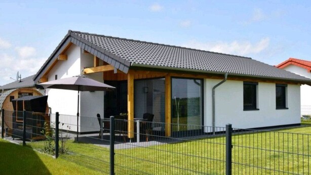 A modern two-story house with a covered patio, a fenced yard, and a clear sky. - Vacation home  by Interhome (Burhave)