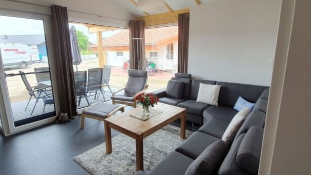 A modern living room with a sofa, chairs, a coffee table, and a view of the outside. - N4 Haus in Nordseenähe mit Terrasse und Garten by Interhome (Burhave)
