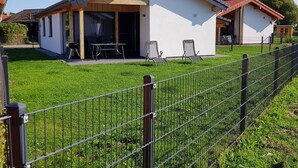 A modern house with a patio, a fenced yard, and a small attached structure. - N4 Haus in Nordseenähe mit Terrasse und Garten by Interhome (Burhave)