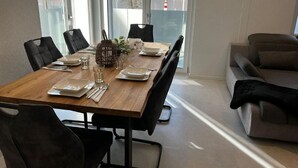 A dining area with a wooden table set for four, surrounded by black chairs. A plant and a lantern are on the table. - mit eigener Terrasse by Interhome (Unterterzen)
