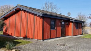 Ein rotes Holzgebäude mit geneigtem Dach und einer Satellitenschüssel.