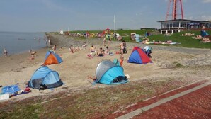 A beach with tents and people. - Eul Ferienhaus F5 by Interhome (Burhave)