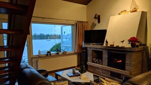 Uma sala de estar aconchegante com lareira, sofá de couro e televisão.
