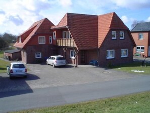 Ein zweistöckiges Haus mit rotem Ziegeldach, einer Garage und einer Auffahrt.