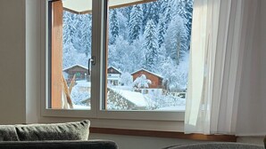 Et værelse med et stort vindue, trægulv og en sofa.