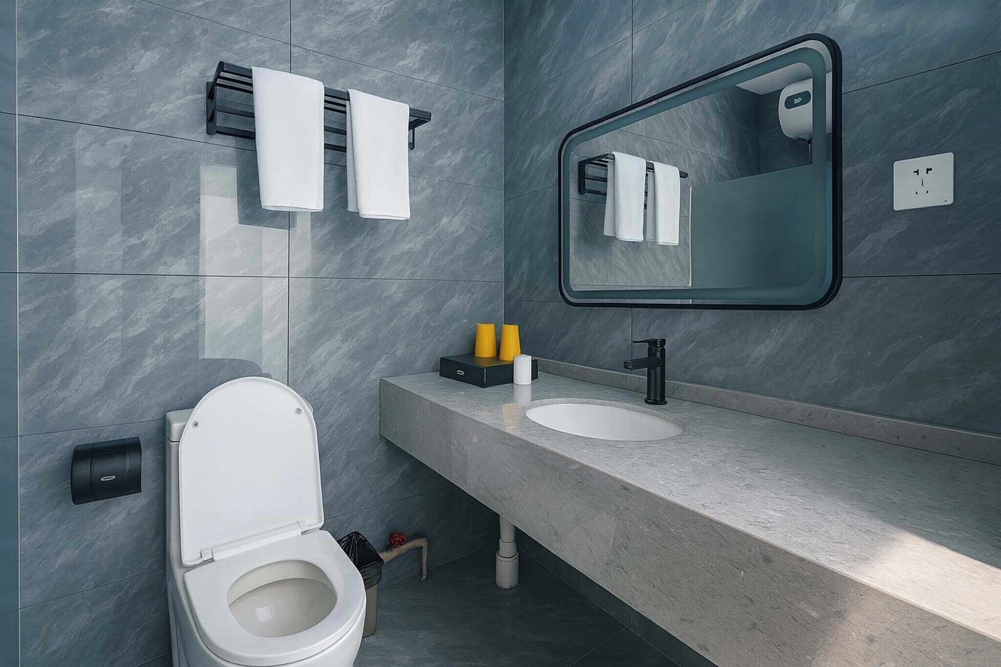 Un baño moderno con inodoro, lavamanos, toallero y espejo.