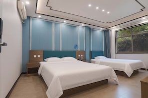 Een hotelkamer met twee bedden, een groot raam met uitzicht op groen en een modern design met blauwe accenten.