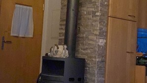 A room with a stone chimney, a wooden door, and a wooden cabinet. - Tscheppa B by Interhome (Camischolas)
