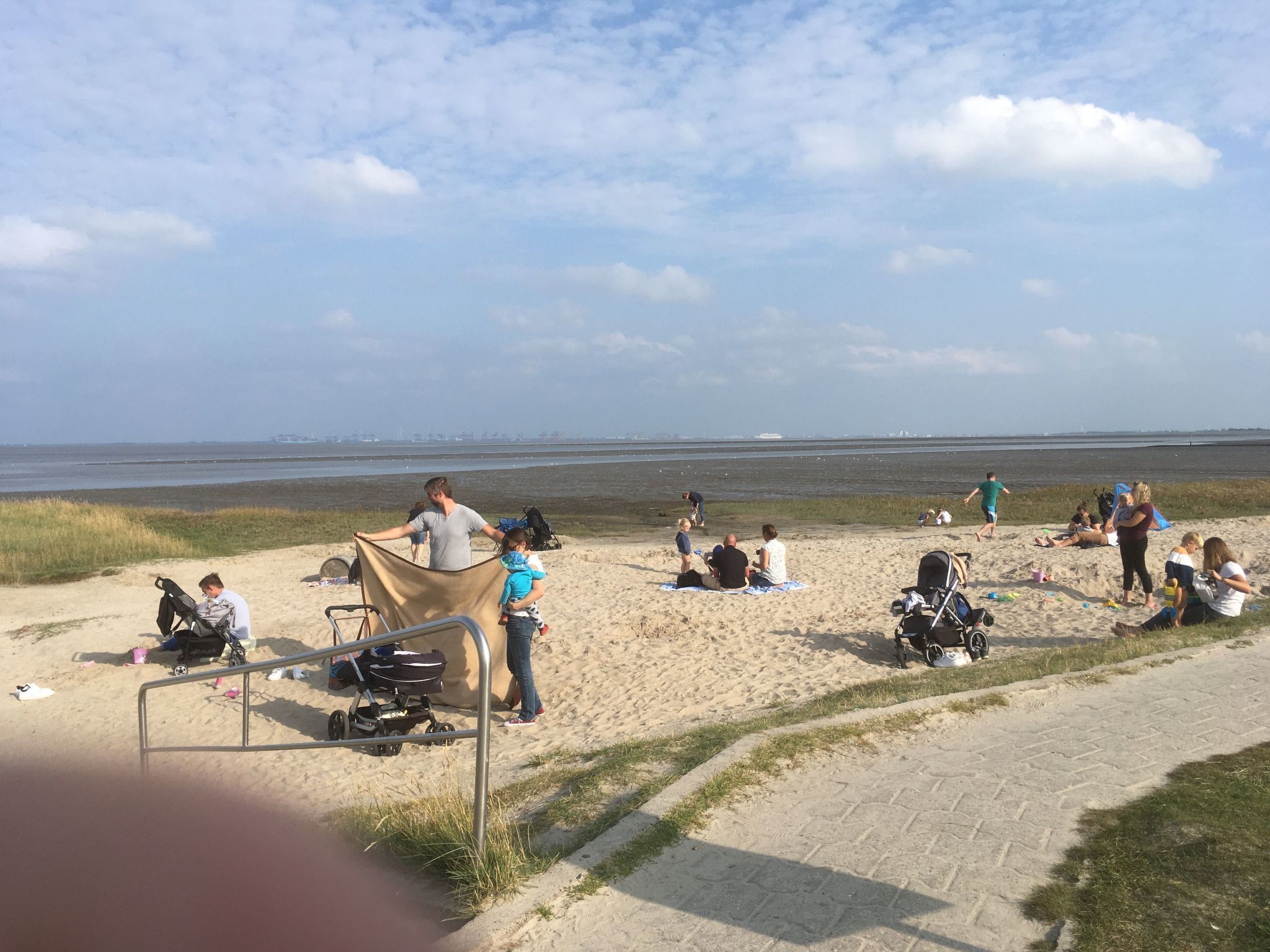 A beach with people relaxing and children playing.