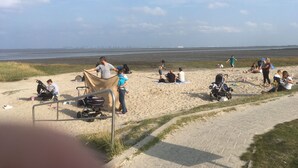A beach with people relaxing and children playing.