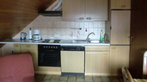 A compact kitchen with a stove, sink, and microwave.