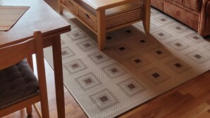 Ein gemütliches Wohnzimmer mit einem Holztisch, zwei Sesseln und einem Sofa.