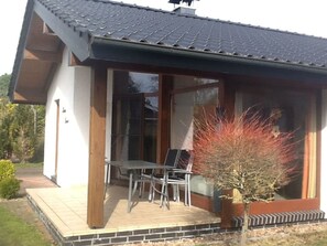 A modern house with a covered patio, a dining table, and chairs. - Haus Luna by Interhome (Burhave)