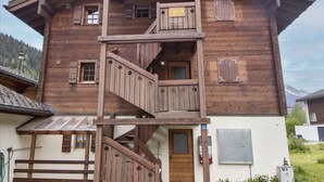 Un edificio in legno con un balcone e una scala che conduce all'ingresso.