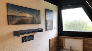 A kitchen with a wooden countertop, a sink, and a window with a view of greenery. There are three framed pictures on the wall. - Tossi Haus 107 in Fedderwardersiel by Interhome (Burhave)